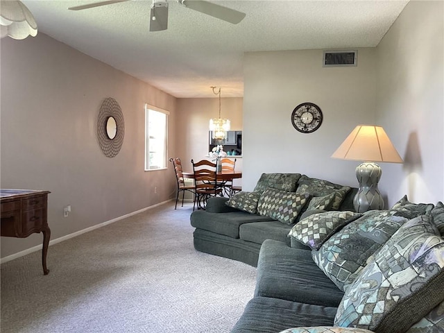 44 Vista Gardens Trail Trl Unit 101, Vero Beach, FL 32962 - living room featuring a ceiling fan, carpet flooring, a chandelier, baseboards, and a textured ceiling