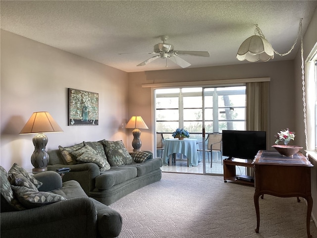 carpeted living room featuring ceiling fan and a textured ceiling