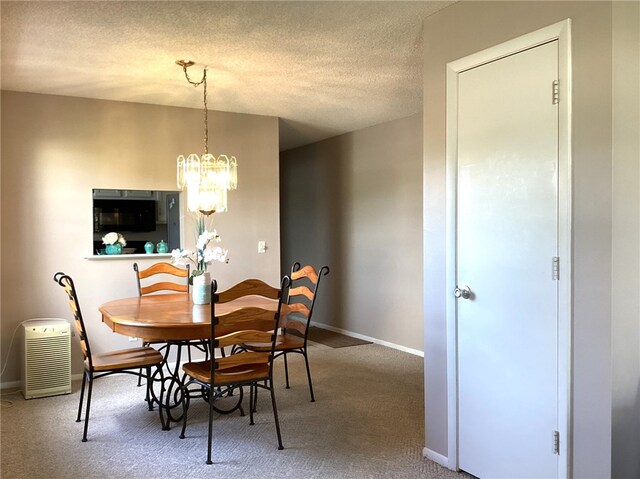 carpeted dining space with a textured ceiling and an inviting chandelier