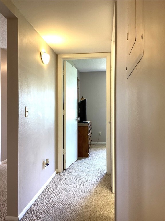 hallway featuring light colored carpet