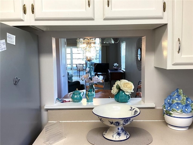 44 Vista Gardens Trail Trl Unit 101, Vero Beach, FL 32962 - kitchen view of white cabinets, a chandelier, and light countertops