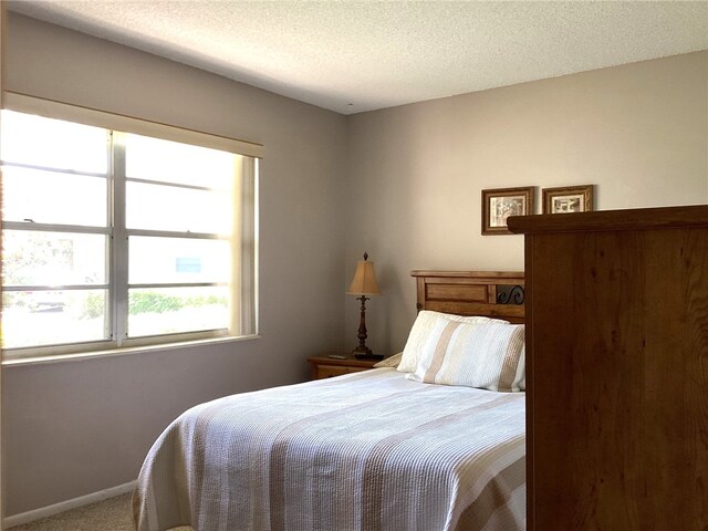 carpeted bedroom featuring a textured ceiling