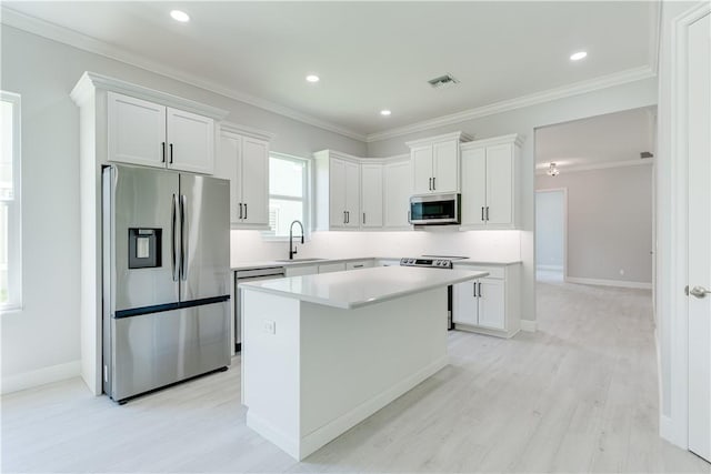 kitchen with appliances with stainless steel finishes, light countertops, white cabinetry, and visible vents