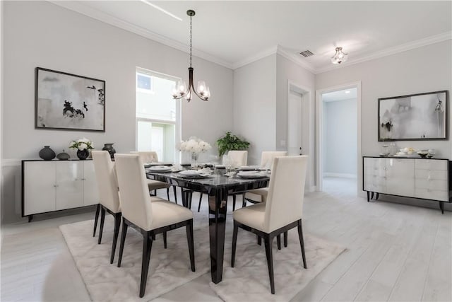 dining area with light wood finished floors, visible vents, crown molding, and an inviting chandelier