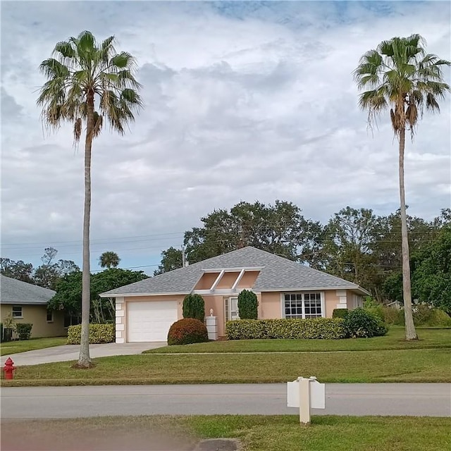 ranch-style house with a garage and a front lawn