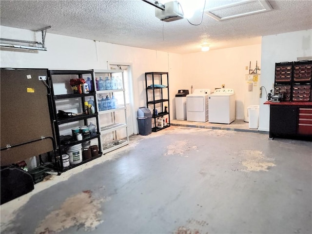 garage with washing machine and clothes dryer, a garage door opener, and water heater