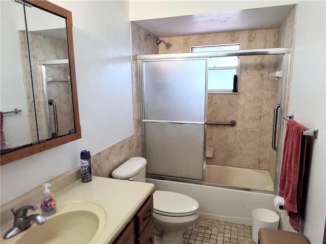 full bathroom featuring toilet, shower / bath combination with glass door, and vanity