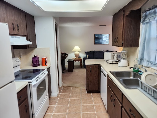 kitchen featuring under cabinet range hood, white appliances, a sink, light countertops, and dark brown cabinets