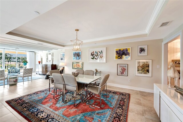 tiled dining space featuring a tray ceiling, an inviting chandelier, and ornamental molding