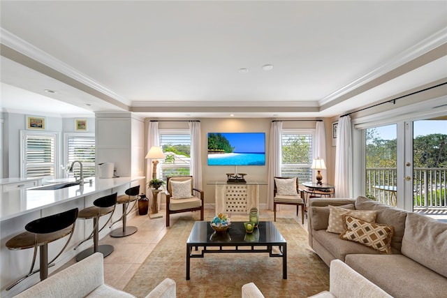 living room featuring light tile patterned flooring, plenty of natural light, sink, and crown molding