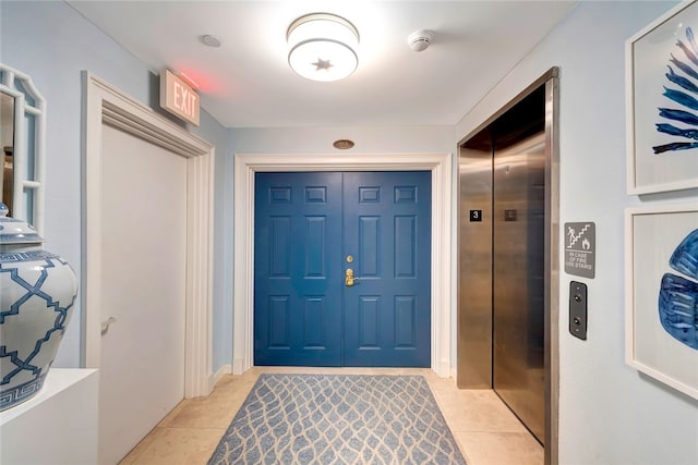 entrance foyer with elevator and light tile patterned flooring