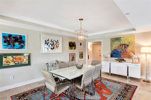 tiled dining area featuring a notable chandelier, crown molding, and a tray ceiling