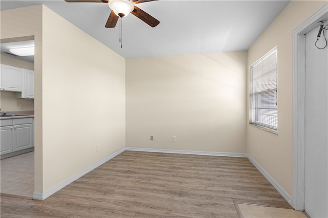 unfurnished room featuring light hardwood / wood-style flooring, ceiling fan, and sink