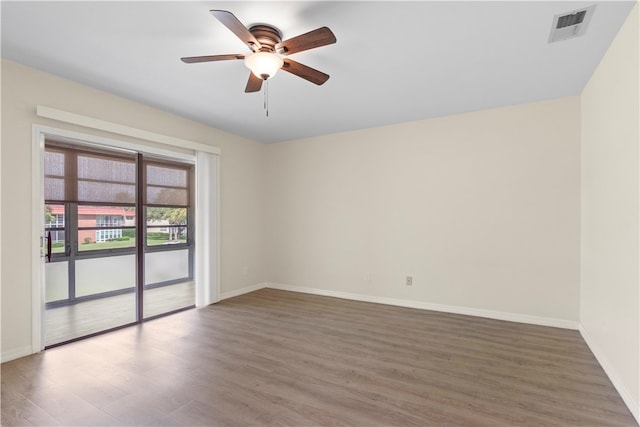 empty room with ceiling fan and dark hardwood / wood-style flooring