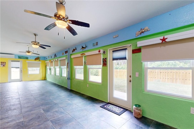 interior space featuring an AC wall unit, vaulted ceiling, and a healthy amount of sunlight