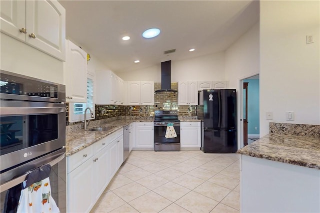 kitchen with stainless steel appliances, wall chimney range hood, light stone countertops, white cabinets, and sink