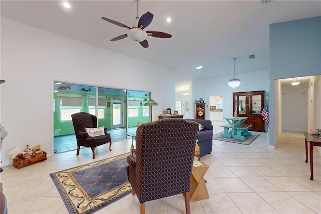 tiled living room featuring ceiling fan and a high ceiling