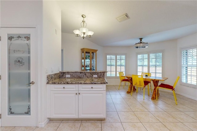 kitchen featuring light tile patterned flooring, stone countertops, white cabinetry, and pendant lighting