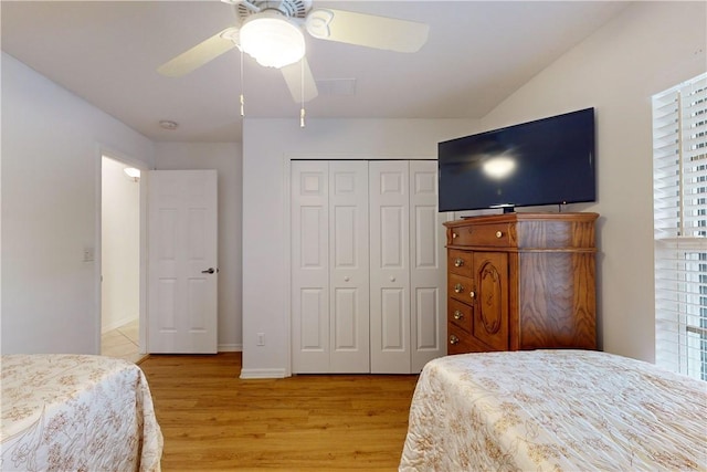 bedroom with ceiling fan, a closet, light wood-type flooring, and multiple windows