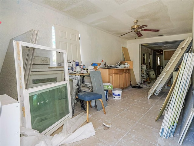 office space featuring tile patterned floors, a ceiling fan, and a textured ceiling