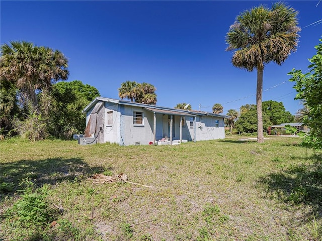 back of property featuring a lawn