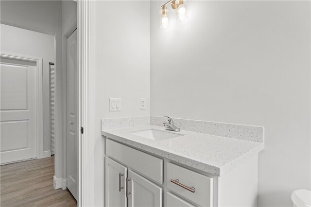 775 11th Ave SW, Vero Beach, FL 32962 - bathroom with vanity, wood finished floors, toilet, and baseboards
