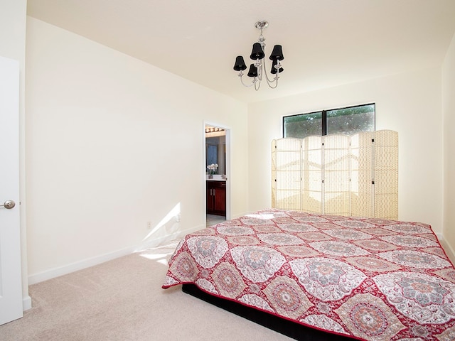 carpeted bedroom featuring a notable chandelier and ensuite bath