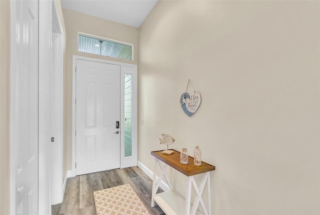 foyer featuring baseboards and wood finished floors