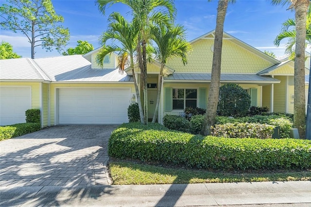 view of front of house featuring metal roof, decorative driveway, and a garage