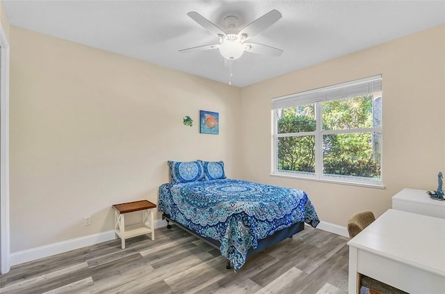 bedroom with baseboards, wood finished floors, and a ceiling fan