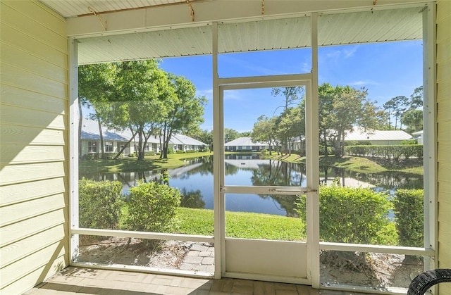 sunroom / solarium featuring a water view