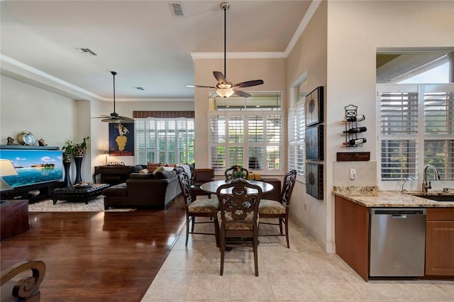 tiled dining area featuring ceiling fan, sink, and ornamental molding