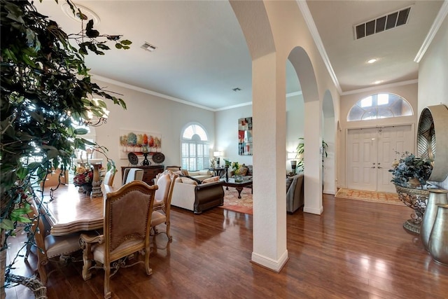 dining area with a high ceiling, dark hardwood / wood-style flooring, and ornamental molding