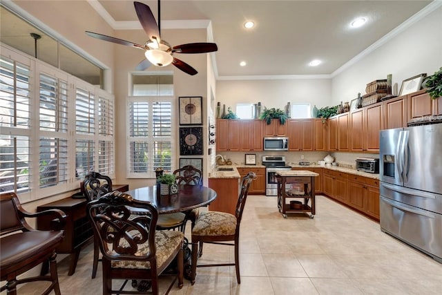 tiled dining room with ceiling fan, crown molding, and sink