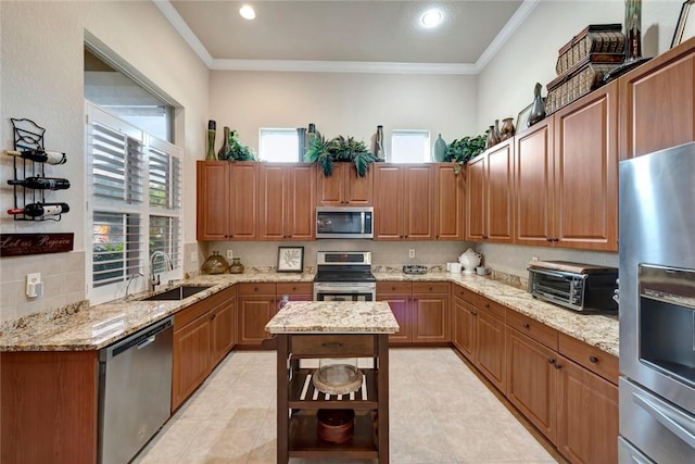 kitchen with light stone counters, sink, ornamental molding, and appliances with stainless steel finishes