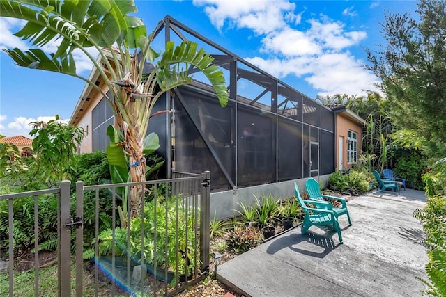 view of side of home featuring a patio area and a lanai