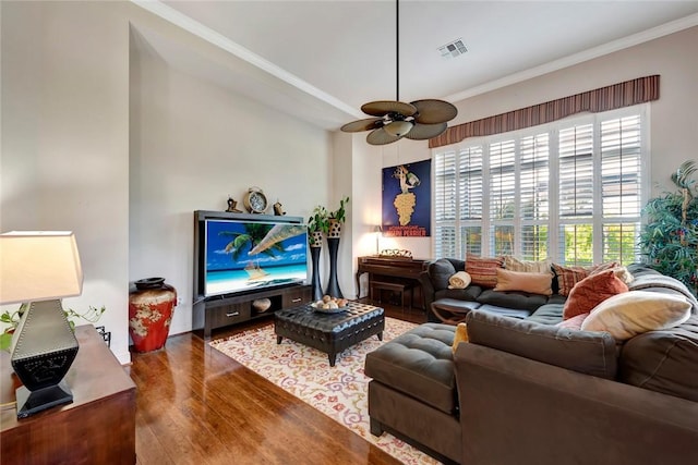 living room featuring crown molding, ceiling fan, and dark wood-type flooring