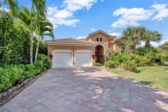 mediterranean / spanish home with a front yard and a garage