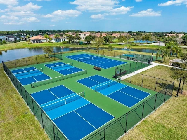 view of tennis court with a water view