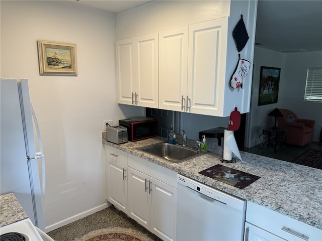 kitchen with white cabinetry, sink, light stone counters, and white appliances