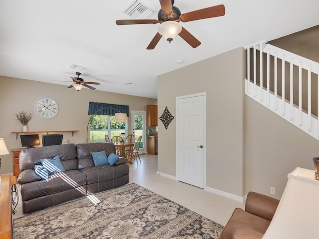 living room featuring stairway, baseboards, visible vents, and a ceiling fan