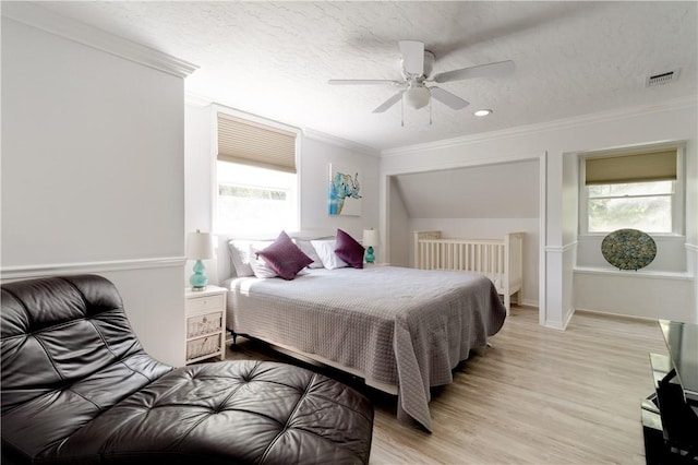 bedroom featuring ornamental molding, ceiling fan, a textured ceiling, and light hardwood / wood-style flooring