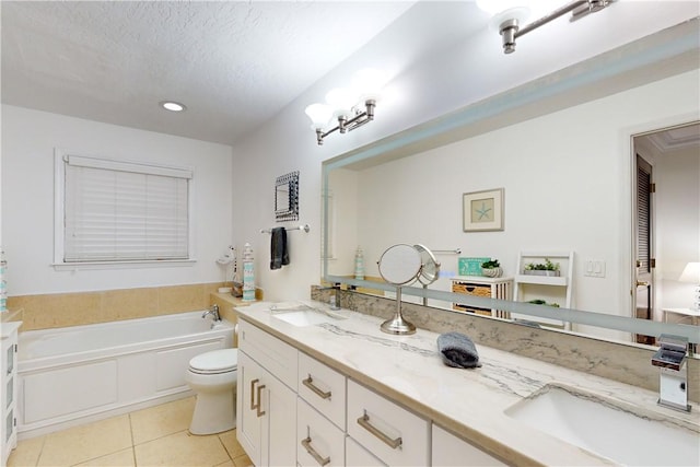 bathroom with a bathing tub, vanity, a textured ceiling, tile patterned floors, and toilet