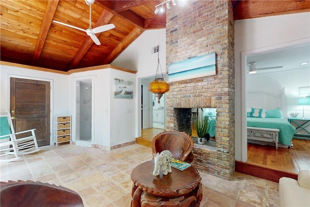 living room featuring vaulted ceiling with beams, a fireplace, wooden ceiling, and ceiling fan