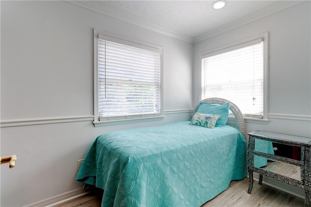 bedroom featuring hardwood / wood-style floors and crown molding