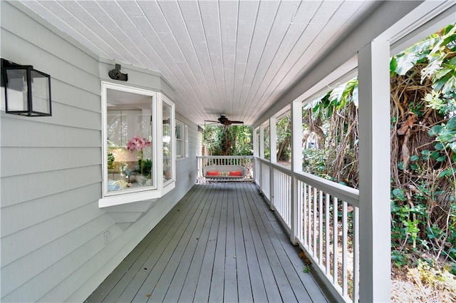 wooden deck featuring covered porch and ceiling fan