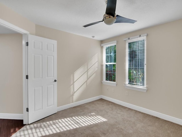 carpeted spare room featuring ceiling fan