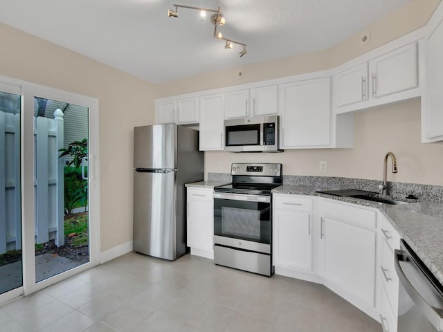 kitchen with light stone counters, white cabinetry, sink, and appliances with stainless steel finishes