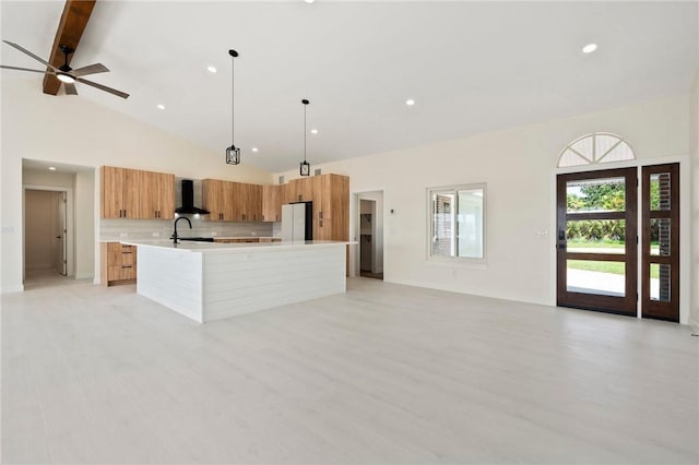 9670 Riverview Dr, Micco, FL 32976 - kitchen with modern cabinets, light countertops, a large island, brown cabinets, and wall chimney exhaust hood