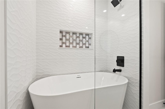 9670 Riverview Dr, Micco, FL 32976 - bathroom featuring tile walls and a freestanding bath